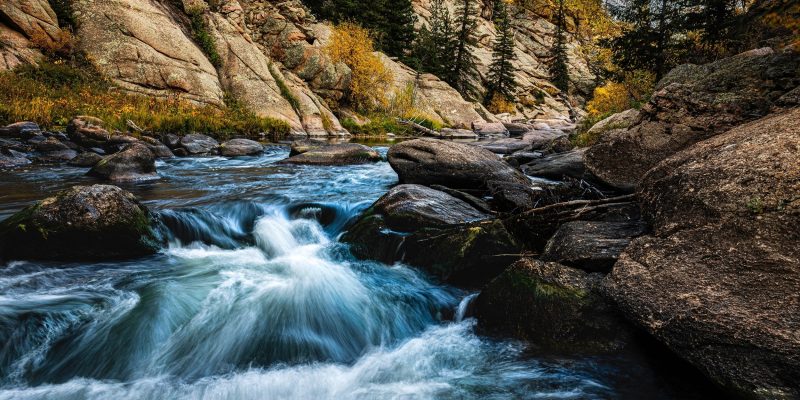 Río en una montaña en un bosque otoñal