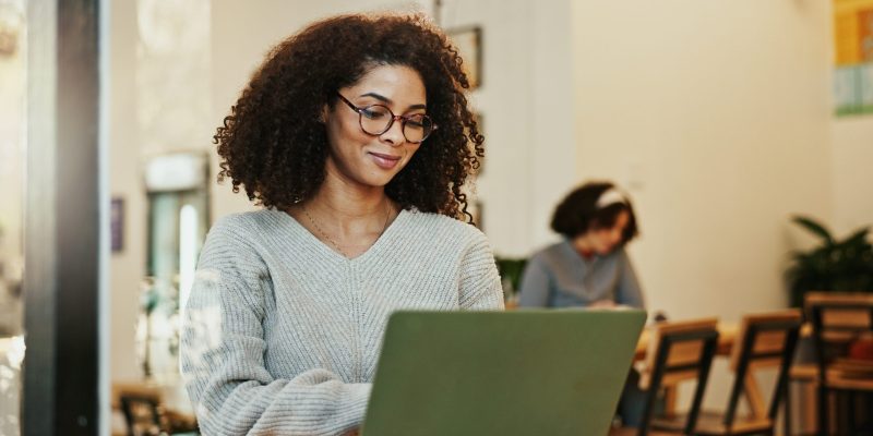 Mujer usando una laptop en una cafetería