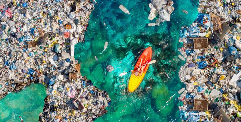 Kayak en medio de la basura en el océano.