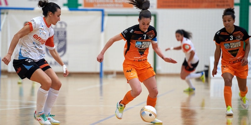 Os jogadores de futsal competem pelo controle da bola.