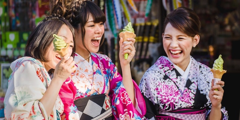 Tres jóvenes simpáticas se ríen mientras toman helado.