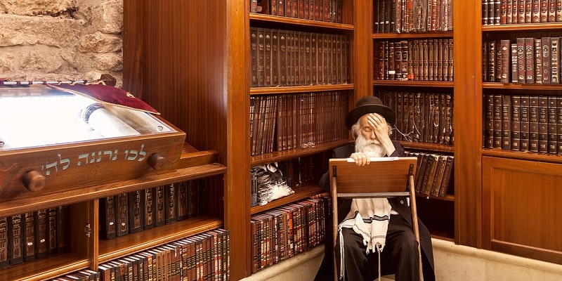 Un rabino estudia el Tanaj en una extensa biblioteca.