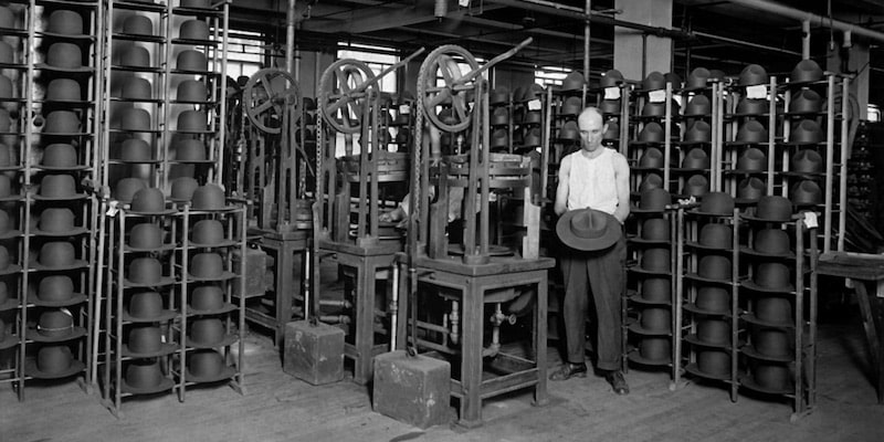 Un trabajador muestra la producción de sombreros en una fábrica.
