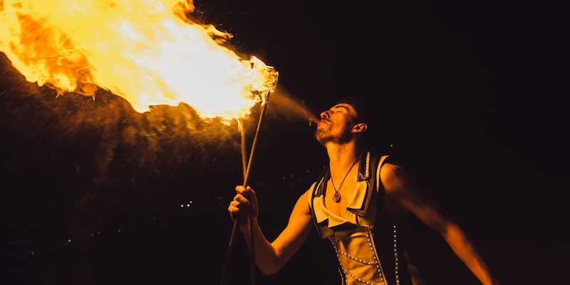 Un artista de circo crea llamas en la oscuridad.