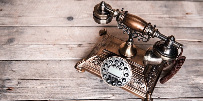 Un antiguo teléfono de principios del siglo veinte se encuentra sobre una mesa.