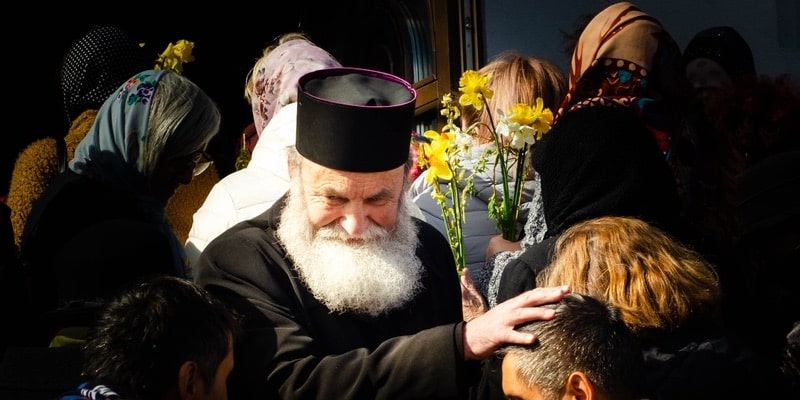 Un sacerdote ortodoxo está rodeado de fieles durante una peregrinación.