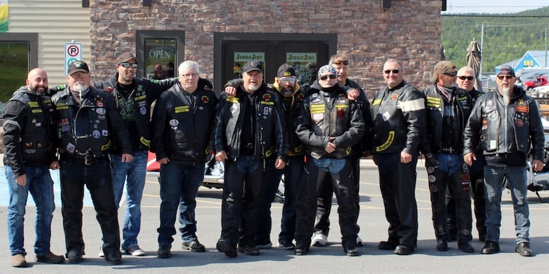 Una pandilla de motociclistas se reúne junto a la carretera.