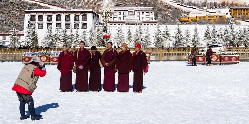 Monjes tibetanos posan frente al Palacio Potala.