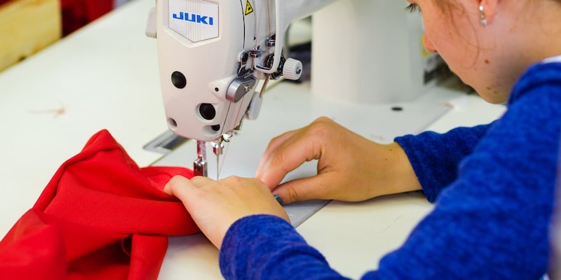 Una costurera utiliza una máquina de coser. 