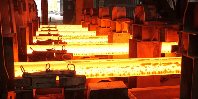 Las barras de acero incandescentes se encuentran en su proceso de producción.