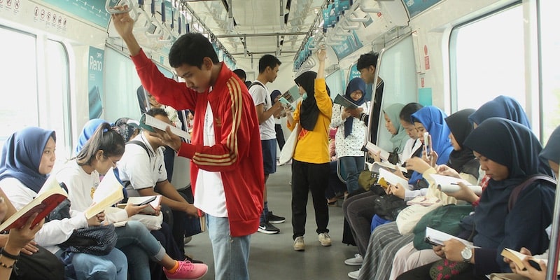 Los pasajeros de un tren leen libros.