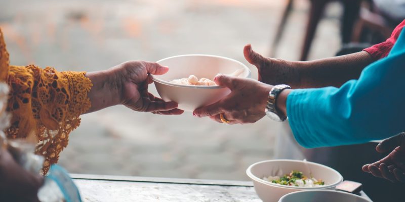 Manos que reparten alimentos