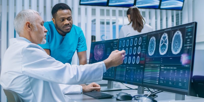 Médico analisando examen médico con su colega.