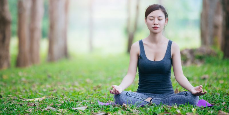 Mujer meditando en el bosque.